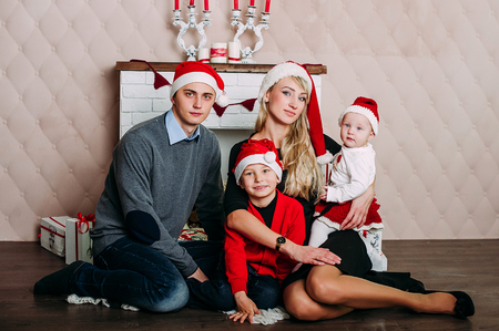 Portrait of friendly family looking at camera on Christmas eveningの写真素材