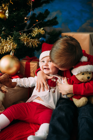 Portrait of happy children with Christmas gift boxes and decorations. Two kids having fun at homeの写真素材