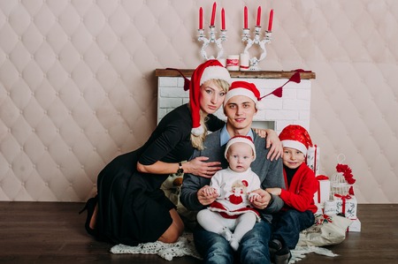 Portrait of friendly family looking at camera on Christmas eveningの写真素材