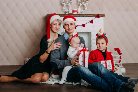 Portrait of friendly family looking at camera on Christmas eveningの写真素材