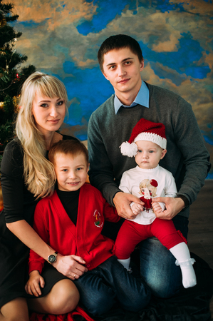 Portrait of friendly family looking at camera on Christmas eveningの写真素材