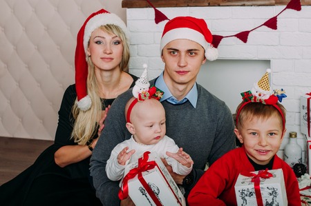 Portrait of friendly family looking at camera on Christmas eveningの写真素材