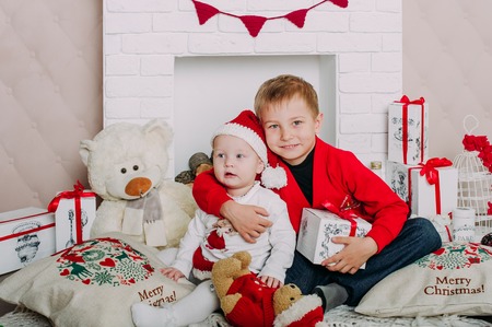 Portrait of happy children with Christmas gift boxes and decorations. Two kids having fun at homeの写真素材