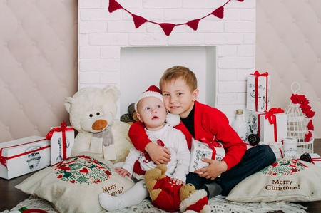 Portrait of happy children with Christmas gift boxes and decorations. Two kids having fun at homeの写真素材