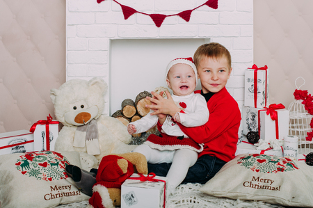 Portrait of happy children with Christmas gift boxes and decorations. Two kids having fun at homeの写真素材