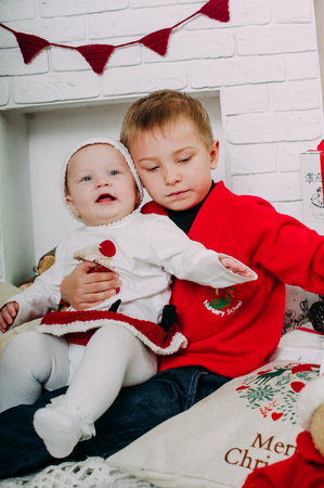 Portrait of happy children with Christmas gift boxes and decorations. Two kids having fun at homeの写真素材