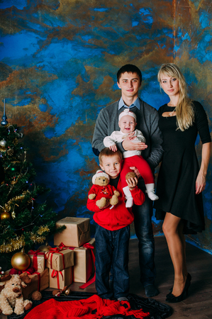 Portrait of friendly family looking at camera on Christmas eveningの写真素材