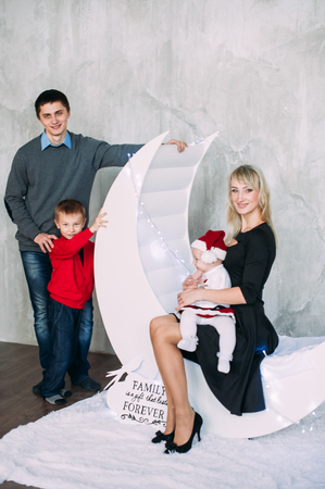 Portrait of friendly family looking at camera on Christmas eveningの写真素材