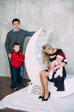 Portrait of friendly family looking at camera on Christmas eveningの写真素材