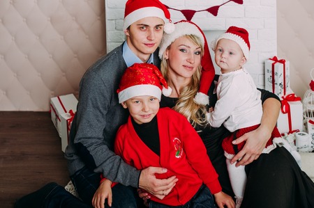 Portrait of friendly family looking at camera on Christmas eveningの写真素材