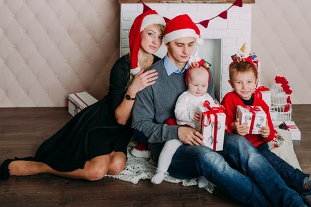 Portrait of friendly family looking at camera on Christmas eveningの写真素材