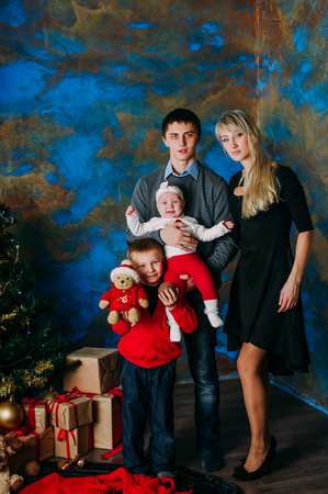 Portrait of friendly family looking at camera on Christmas eveningの写真素材
