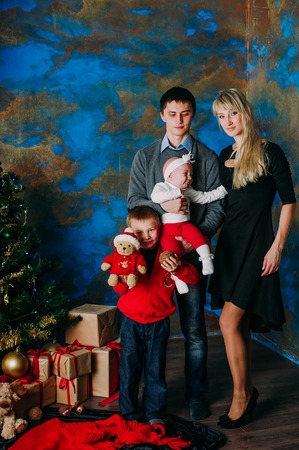 Portrait of friendly family looking at camera on Christmas eveningの写真素材