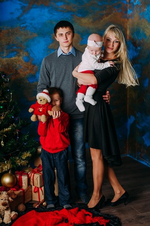 Portrait of friendly family looking at camera on Christmas eveningの写真素材