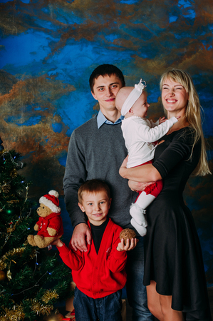 Portrait of friendly family looking at camera on Christmas eveningの写真素材