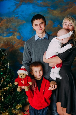 Portrait of friendly family looking at camera on Christmas eveningの写真素材