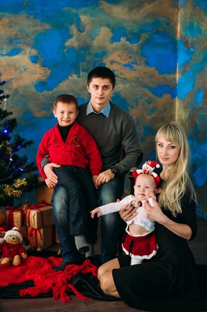 Portrait of friendly family looking at camera on Christmas eveningの写真素材