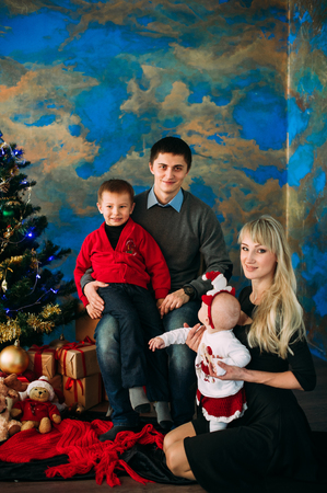 Portrait of friendly family looking at camera on Christmas eveningの写真素材