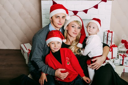Portrait of friendly family looking at camera on Christmas eveningの写真素材