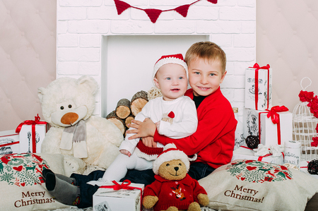 Portrait of happy children with Christmas gift boxes and decorations. Two kids having fun at homeの写真素材