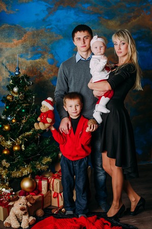 Portrait of friendly family looking at camera on Christmas eveningの写真素材