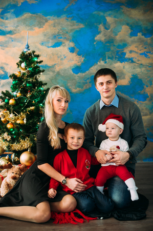 Portrait of friendly family looking at camera on Christmas eveningの写真素材
