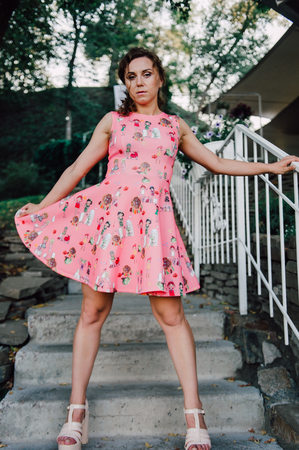 Beautiful brunette girl posing in pink dress outside near tropical plantsの写真素材