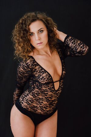 Sexy and beautiful woman wearing black lace body lingerie with curly hairの写真素材