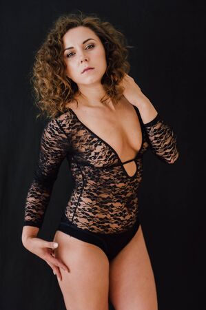 Sexy and beautiful woman wearing black lace body lingerie with curly hairの写真素材