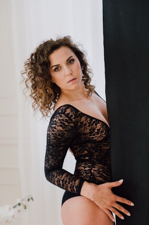 Sexy and beautiful woman wearing black lace body lingerie with curly hairの写真素材