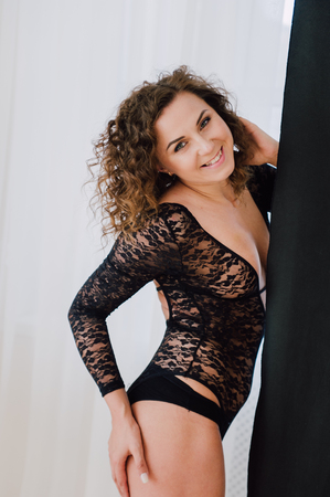 Sexy and beautiful woman wearing black lace body lingerie with curly hairの写真素材