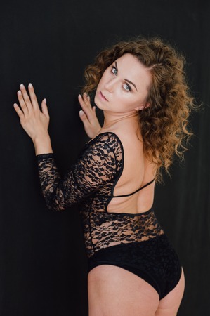 Sexy and beautiful woman wearing black lace body lingerie with curly hairの写真素材