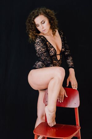 Sexy and beautiful woman wearing black lace body lingerie with curly hairの写真素材