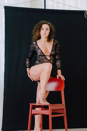 Sexy and beautiful woman wearing black lace body lingerie with curly hairの写真素材
