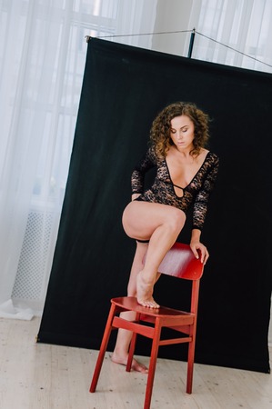 Sexy and beautiful woman wearing black lace body lingerie with curly hairの写真素材