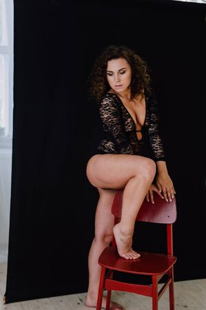 Sexy and beautiful woman wearing black lace body lingerie with curly hairの写真素材
