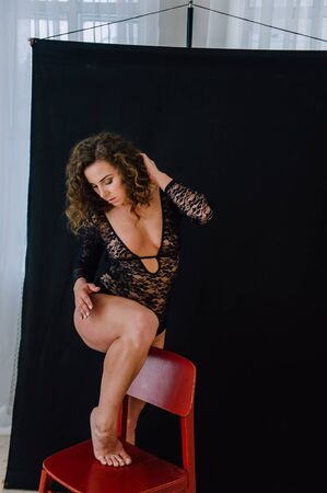 Sexy and beautiful woman wearing black lace body lingerie with curly hairの写真素材