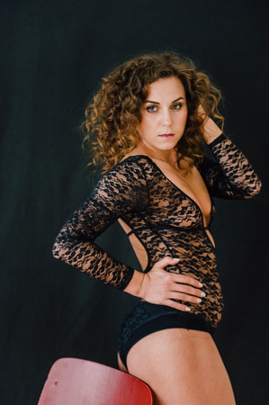 Sexy and beautiful woman wearing black lace body lingerie with curly hairの写真素材