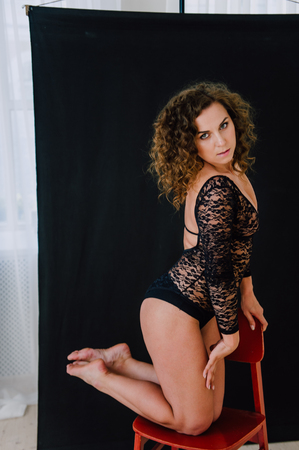 Sexy and beautiful woman wearing black lace body lingerie with curly hairの写真素材