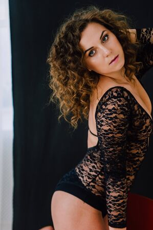 Sexy and beautiful woman wearing black lace body lingerie with curly hairの写真素材