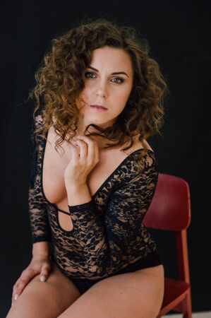 Sexy and beautiful woman wearing black lace body lingerie with curly hairの写真素材