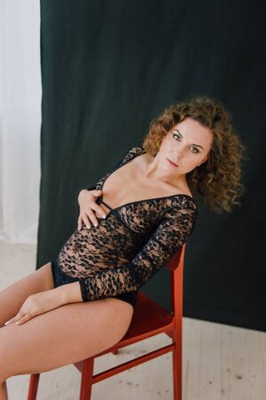 Sexy and beautiful woman wearing black lace body lingerie with curly hairの写真素材