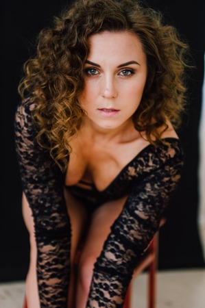 Sexy and beautiful woman wearing black lace body lingerie with curly hairの写真素材
