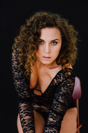 Sexy and beautiful woman wearing black lace body lingerie with curly hairの写真素材