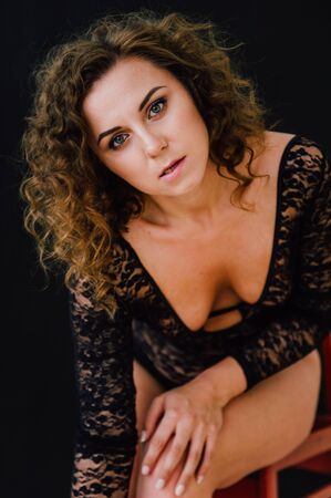 Sexy and beautiful woman wearing black lace body lingerie with curly hairの写真素材