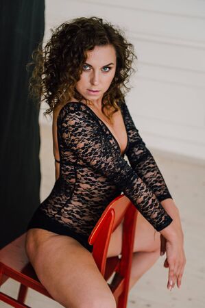 Sexy and beautiful woman wearing black lace body lingerie with curly hairの写真素材