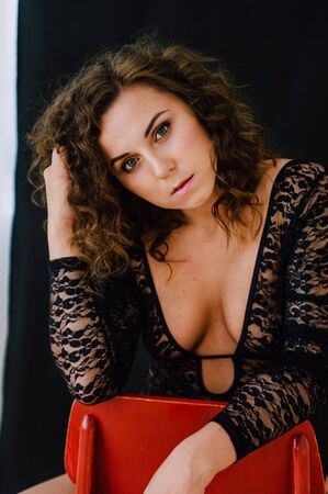 Sexy and beautiful woman wearing black lace body lingerie with curly hairの写真素材
