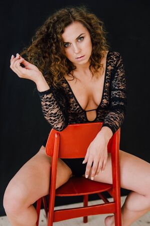 Sexy and beautiful woman wearing black lace body lingerie with curly hairの写真素材
