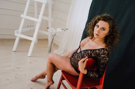 Sexy and beautiful woman wearing black lace body lingerie with curly hairの写真素材