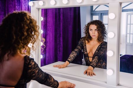 Sexy and beautiful woman wearing black lace body lingerie with curly hairの写真素材